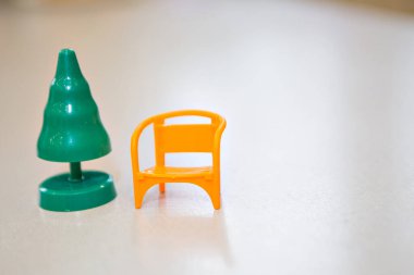 Plastik yeşil Noel ağacı ve Noel Baba 'ya yeni yıl için küçük sarı bir sandalye. Beyaz bir arka planda izole edilmiş. Boşluğu kopyala