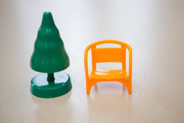 Plastik yeşil Noel ağacı ve Noel Baba 'ya yeni yıl için küçük sarı bir sandalye. Beyaz bir arka planda izole edilmiş. Boşluğu kopyala