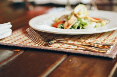 Kızarmış chiken, bıldırcın yumurtası, marul yaprağı, tost, parmesan, domates ve krema soslu klasik Sezar salatası servis edilen masaya yakın. İtalyan mutfağı