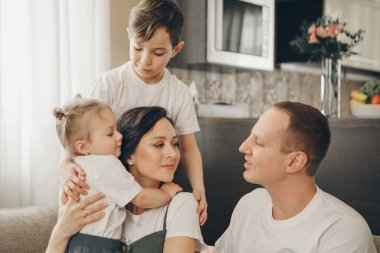 İki çocuklu bir aile kanepede oturuyor. Hafta sonu evde. Birlikte vakit geçirmek.