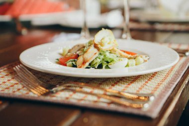 Kızarmış chiken, bıldırcın yumurtası, marul yaprağı, tost, parmesan, domates ve krema soslu klasik Sezar salatası servis edilen masaya yakın. İtalyan mutfağı