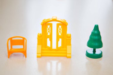 Plastik yeşil bir Noel ağacı, küçük sarı bir sandalye ve Noel Baba için büyük bir kapı. Beyaz bir arka planda izole edilmiş. Boşluğu kopyala