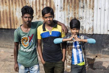 Barisal, Bangladeş, 27 Şubat 2017: Barisal bağlantı noktası bir iskele üzerinde üç genç poz. Bir genç bir kalp elleri ile yapar