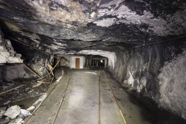 Railway tracks in a tunnel of an abandoned lime mine in Switzerland clipart