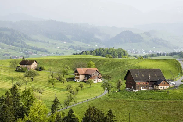 Foggy spring day with farms in the Entlebuch in the canton of Lucerne in central Switzerland