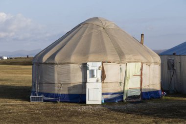 Şarkı Kul, Kırgızistan, 8 Ağustos 2018: Gün batımında Kırgızistan'şarkı Kul gölde Lavabo ile geleneksel Yurt