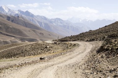 Pamir Otoyolu Tacikistan 'daki Pamir Dağları' nın çöl manzarasında. Afganistan solda.