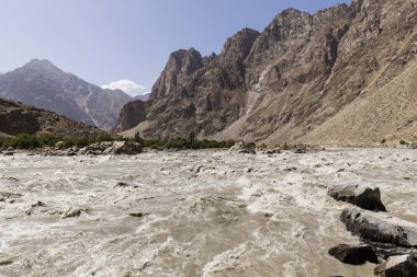 Border river Panj River in Wakhan valley with Tajikistan right and Afghanistan left clipart