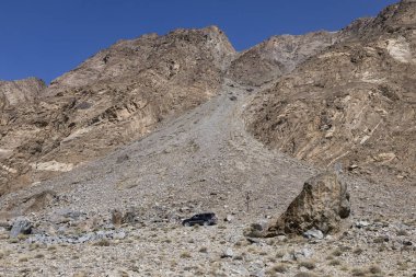 Khorog, Tajikistan August 24 2018: Offroad car on the Pamir Highway in a canyon in the Wakhan valley in Tajikistan clipart