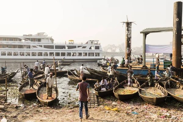 Dhaka, Bangladesh, 24 de febrero de 2017: Pequeños botes de remos sirven como taxi entre las dos orillas del río Buriganga en Dhaka Bangladesh, en el fondo el muelle — Foto de Stock