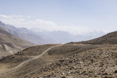 Pamir Otoyolu Tacikistan 'daki Pamir Dağları' nın çöl manzarasında. Afganistan solda.