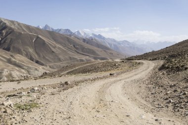 Pamir Otoyolu Tacikistan 'daki Pamir Dağları' nın çöl manzarasında. Afganistan solda.