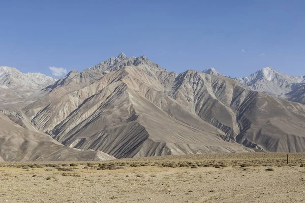 Mooi landschap in het Pamir gebergte. Uitzicht vanuit Tadzjikistan jegens Afghanistan op de achtergrond met de bergtoppen — Stockfoto