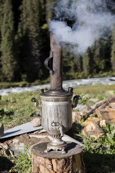 Een Samowar staat buiten een yurt in de vallei van Altyn-Arashan. Het wordt gevoed met hout en levert warm water voor de thee hele dag lang — Stockfoto