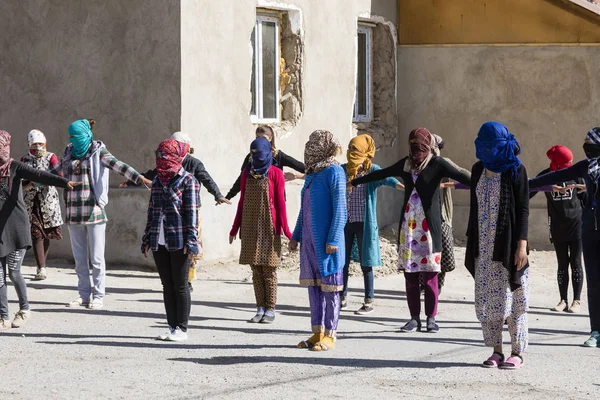 Murghab, Tadzsikisztán, augusztus 23 2018: Kirgiz lányok és fiatal nők gyakorló a tánc, a játszótéren, egy iskola Murghab. Az erős napfény ellen azok védtük az arcukat, sálak. — Stock Fotó
