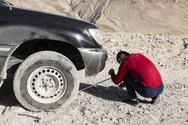 Langar, Tayikistán, 23 de agosto de 2018: Reparación de un neumático pinchado en la autopista Pamir, cerca de Langar, en la zona fronteriza entre Tayikistán y Afganistán — Foto de Stock
