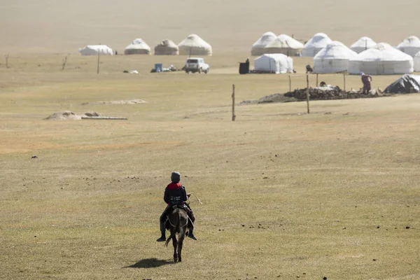 Song Kul, Kyrgyzstán, 8 srpen 2018: Dítě jezdí Osla do jurty tábora u jezera Song Kul v Kyrgyzstánu — Stock fotografie
