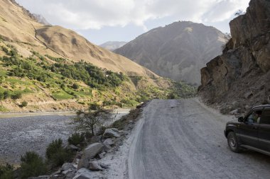Khorog, Tacikistan 24 Ağustos 2018: Offroad araba Tacikistan (Afganistan sol tarafında Vahan Vadisi'nde bir kanyonda Pamir karayolu üzerinde)