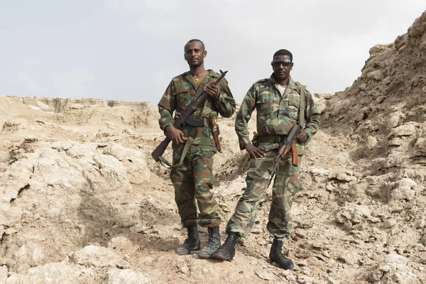 Danakil, Etiópia, január 22 2015: két katona pózol büszkén a fegyvereket a sós hegyek a Danakil sivatagban — Stock Fotó