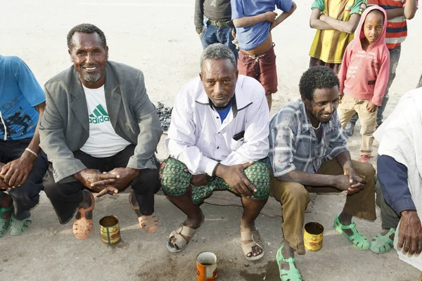 Hamd ELA, Etiopia, luty 23 2015: etiopskie mężczyźni siedzą na zewnątrz na ulicy mówienia i picia lokalnego napoju ze starych cyny puszki — Zdjęcie stockowe