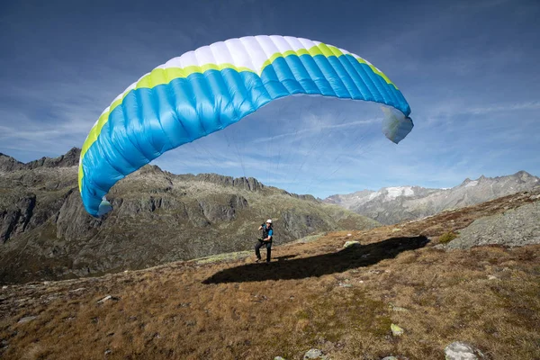 若いパラグライダーパイロットは、スイスアルプスの風で遊ぶために彼のパラグライダーを使用します, いわゆるグランドハンドリング — ストック写真