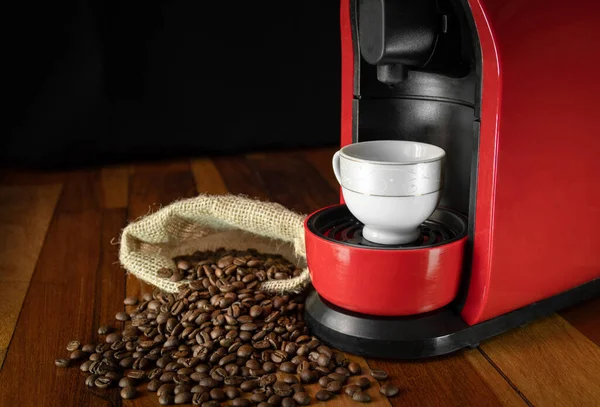 Red coffee maker with coffee cup waiting