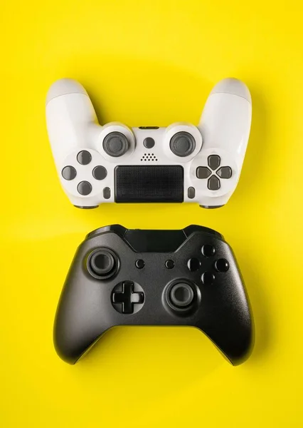 黄色の背景に黒と白のゲームコントローラー — ストック写真