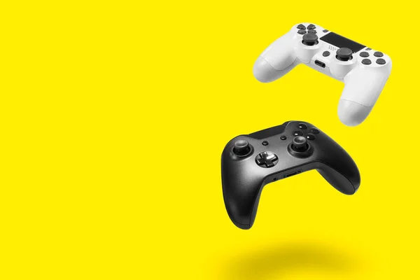 黄色の背景に白と黒のゲームコントローラー — ストック写真
