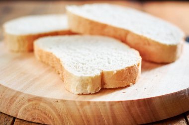 Taze dilim ekmek ahşap plaka üzerinde. alan sığ derinliği