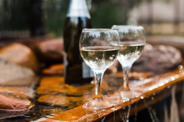 Aşk, romantizm, tatil, kutlama kavramı. Şişe ve bardak yaz orman şelale tarafından sunset Bulvarında soğutulmuş şampanya.