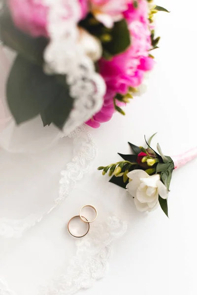 Güzel pembe peonies buket ve Alyans beyaz masaya yalan. Üstten görünüm. 