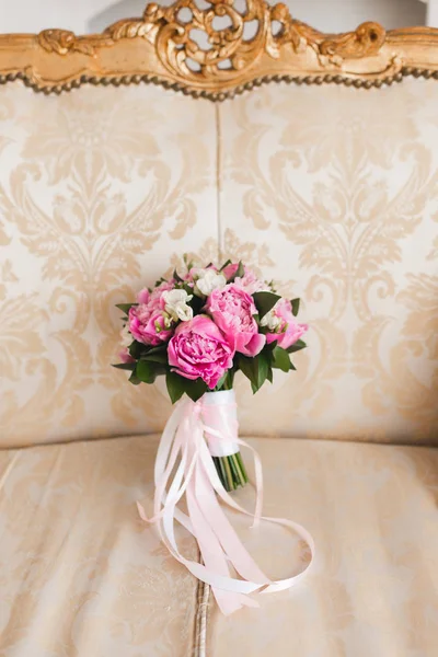 Pembe ve beyaz vintage bej koltuk üzerinde beyaz bantlar ile buket düğün. Portre