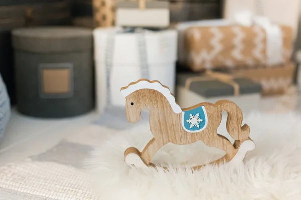 Toy horse with Christmas gifts on  background