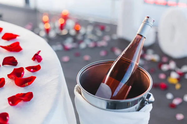 Bir şişe şampanya gül yaprakları ile closeup