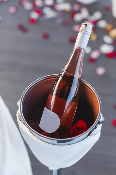Bir şişe şampanya gül yaprakları ile closeup