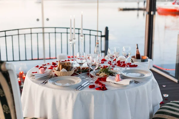Romantic Valentine Day Dinner Setting Rose Petals Empty Wineglasses Sunset — Stock Photo, Image