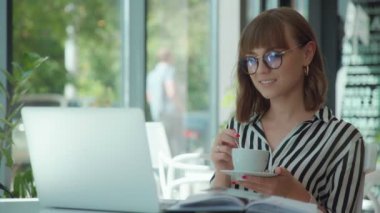 Zarif kadın kahve içme, tarassut video üstünde belgili tanımlık laptop perde