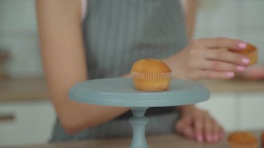 Kadın pudra muffin kek dekorasyon süreci ile mutfak günlüğü kaydetmek için şekerleme standı koyar. Şekerleme dekorasyon: bir capcake hazırlanması.
