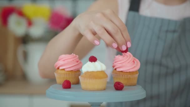 Capkakes apetitosos com creme branco e rosa em uma banca de bolo . — Vídeo de Stock