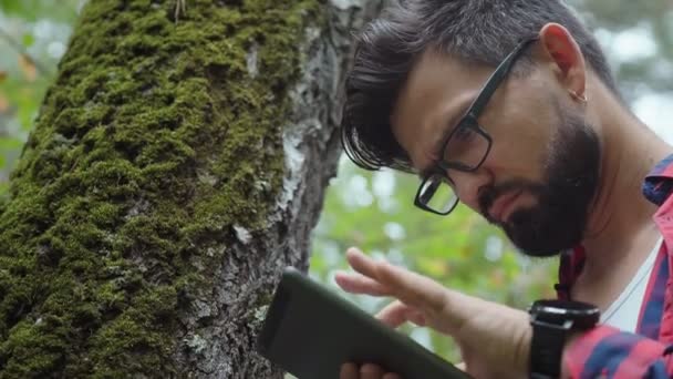 Botaniker mit Brille und Tablette forscht. — Stockvideo