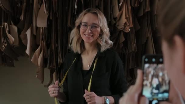 Seamstress é fotografado no fundo de desenhos de roupas — Vídeo de Stock