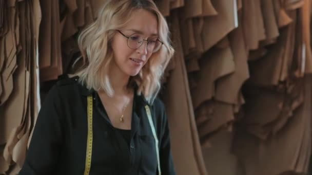 Young female fashion designer or seamstress in her textured studio. — Stock Video