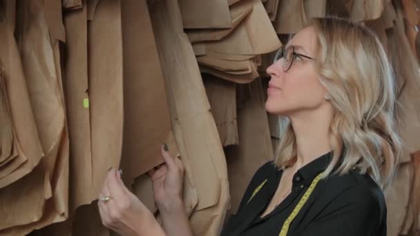 Elegante costurera rubia en el proceso de trabajo en un estudio de costura . — Vídeos de Stock