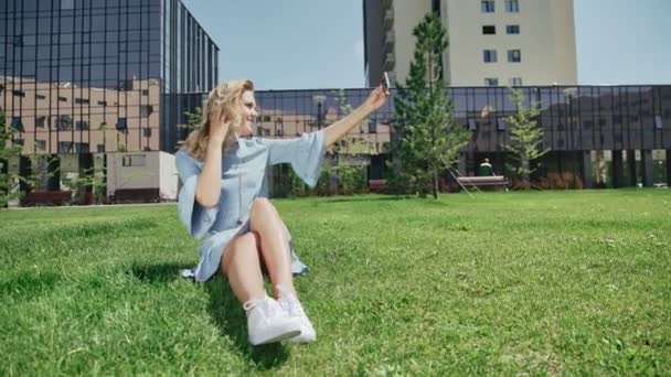 Mujer joven en jeans vestido con teléfono inteligente toma fotos — Vídeos de Stock