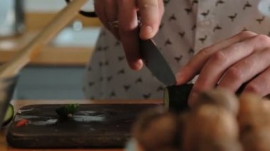Erkek el salatalık koyu ahşap kesme tahtası üzerinde halkalar halinde kesilmiş