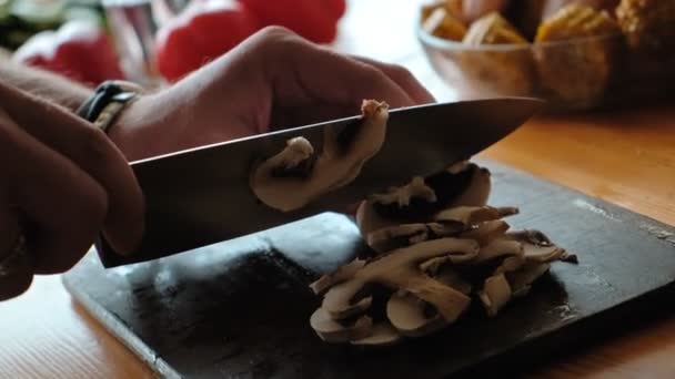 Um homem corta champignon com uma grande faca de metal. Blog de comida. Close-up — Vídeo de Stock
