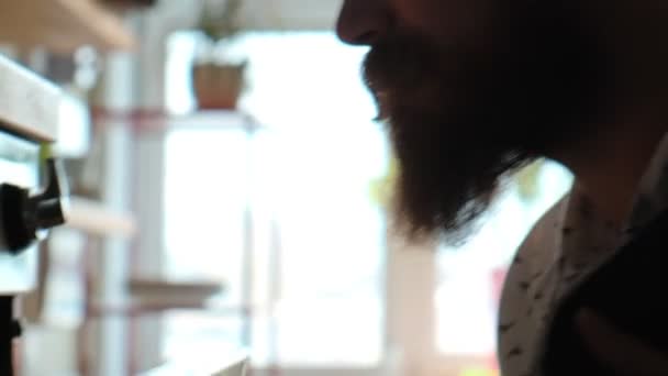 Профиль мужчины-повара с бородой и усами, смотрящего в духовку — стоковое видео