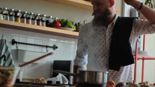 Чоловік готує і танцює. харизматичний чоловічий хіпстер на кухні — стокове відео