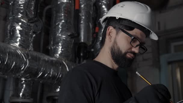 Homem de capacete, óculos, t-shirt preta olha para a câmera sorrindo — Vídeo de Stock