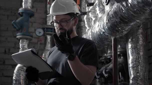 Plombier dans la salle technique parle dans le message audio du téléphone haut-parleur — Video